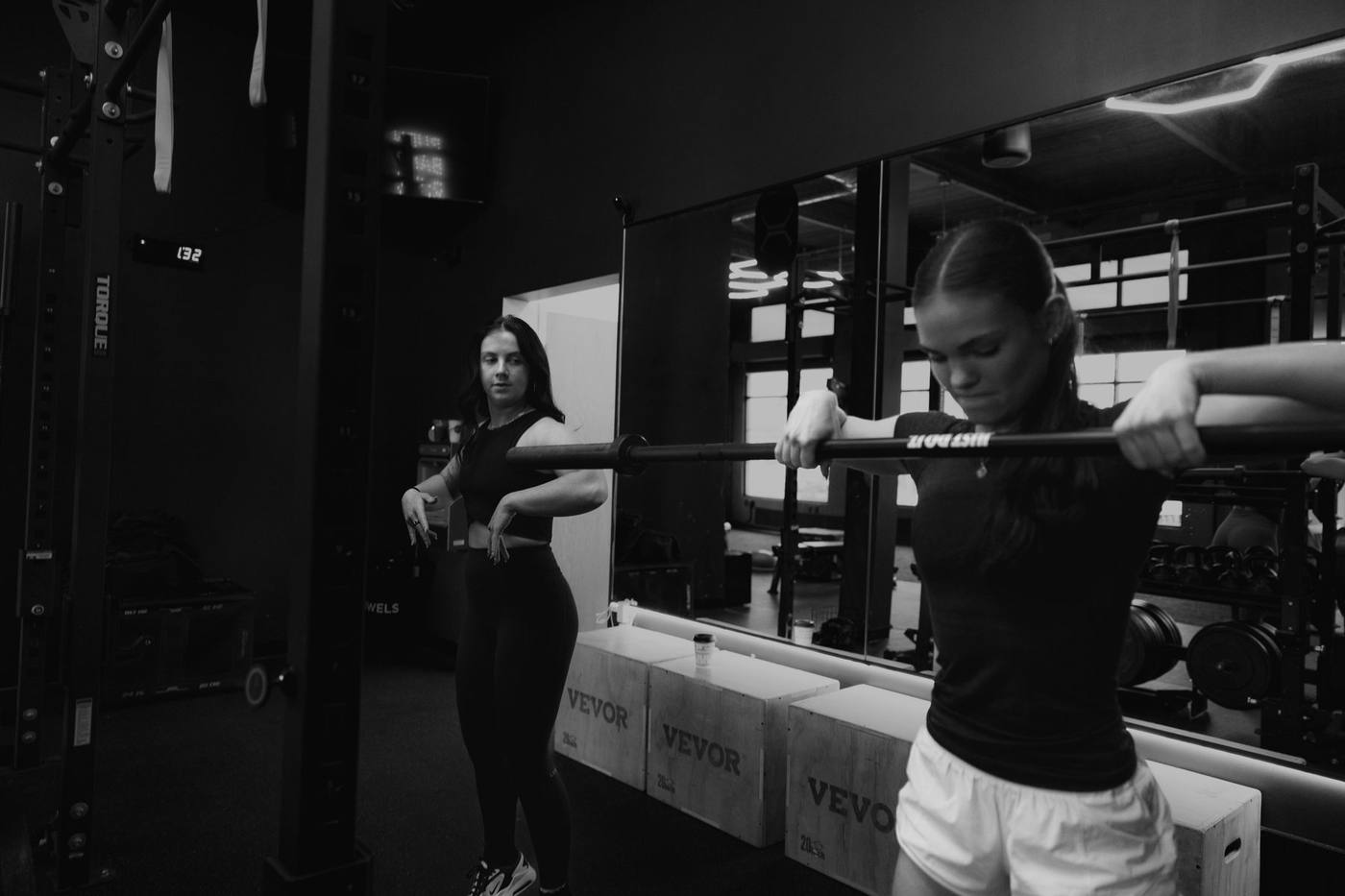 A coach guiding barbell work at Evolve