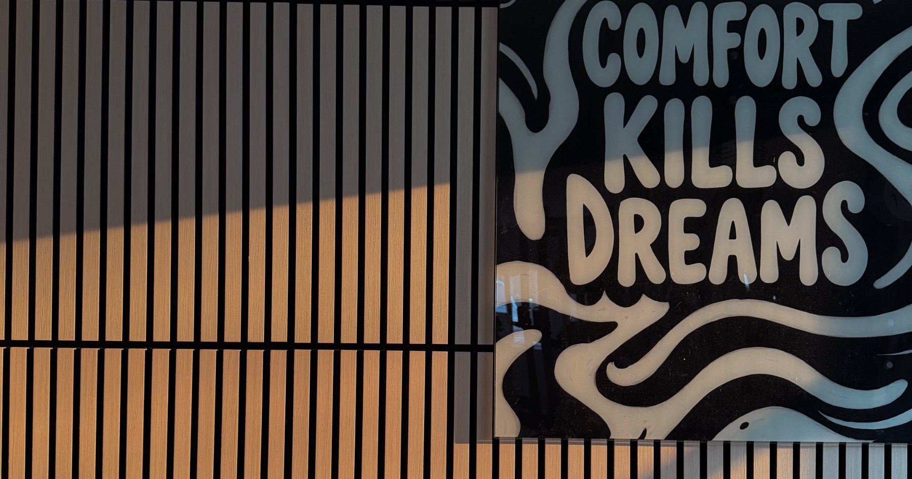 Evolve: oak slat walls and the Comfort Kills Dreams mural